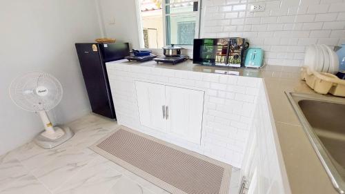 a kitchen with a counter with a refrigerator and a fan at Billabong Village in Ko Phangan