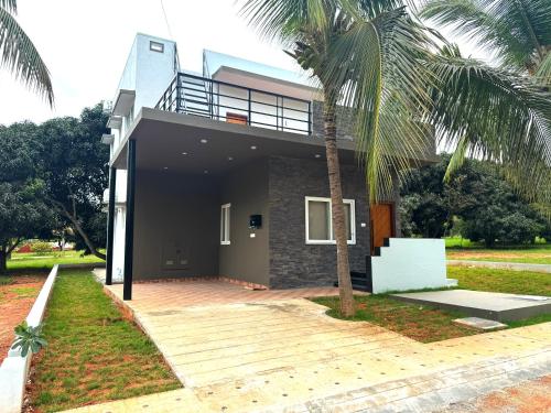 a house with a palm tree in front of it at Nandi Daybreak - Holiday Homes in Bengaluru