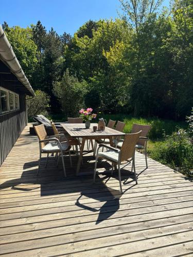 a wooden deck with a table and chairs on it at Hidden Gem By Thy National Park in Bedsted