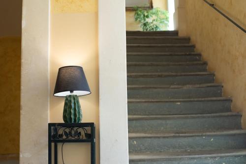 a lamp sitting on a table next to a staircase at Residence Acropoli in Siracusa