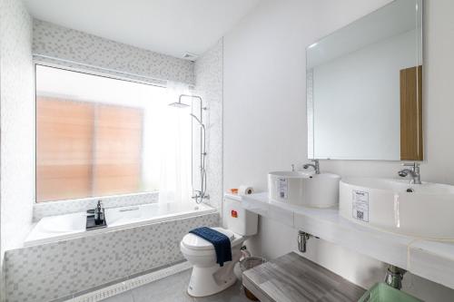 a bathroom with a toilet and a sink and a mirror at Andaman Sea Best Pool Access and Villas in Phuket Town