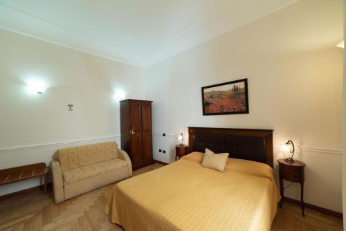 a bedroom with a bed and a chair at Residence Acropoli in Siracusa