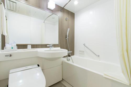 a white bathroom with a sink and a toilet at Mars Garden Hotel Hakata in Fukuoka