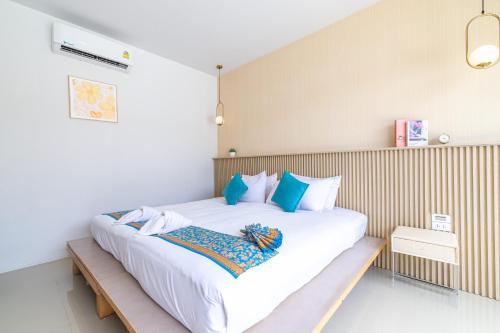 a bedroom with a large white bed with blue pillows at Andaman Sea Best Pool Access and Villas in Phuket Town