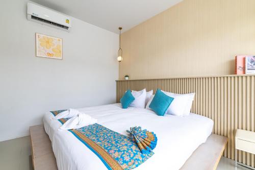 a bedroom with two white beds with blue pillows at Andaman Sea Best Pool Access and Villas in Phuket Town