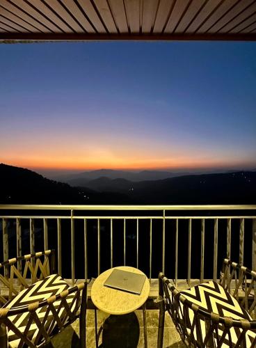 a table and chairs on a balcony with a view at Hotel Cloud End Lansdowne in Lansdowne