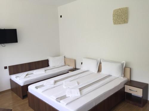 two beds in a room with a tv at Paradox Oituz in Eforie Sud