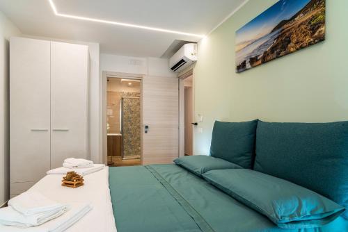 a bedroom with a green bed and a white table at Brezza marina in Santa Maria di Castellabate