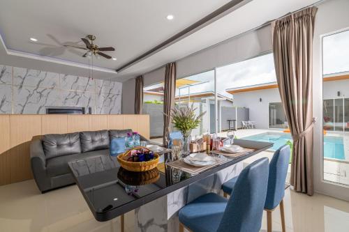 a dining room and living room with a table and chairs at Andaman Sea Best Pool Access and Villas in Phuket Town