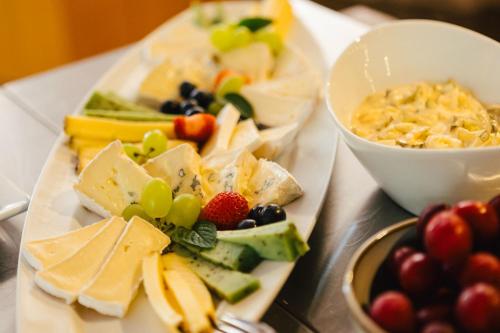 a plate of cheese and fruit on a table at Hotel Rabenstein in Raben Steinfeld