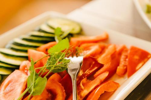 a plate of food with a fork and vegetables at Hotel Rabenstein in Raben Steinfeld