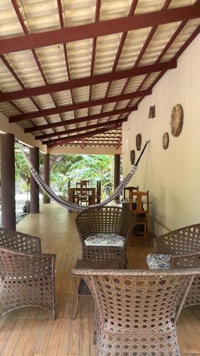 a porch with wicker chairs and a hammock at Constancy residence in Itarema