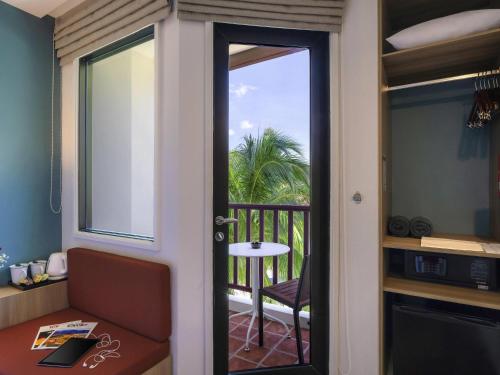 a room with a door leading to a balcony at Ibis Phuket Patong in Patong Beach