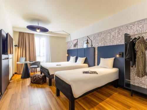 a hotel room with two beds and a table at ibis Dunkerque in Dunkerque