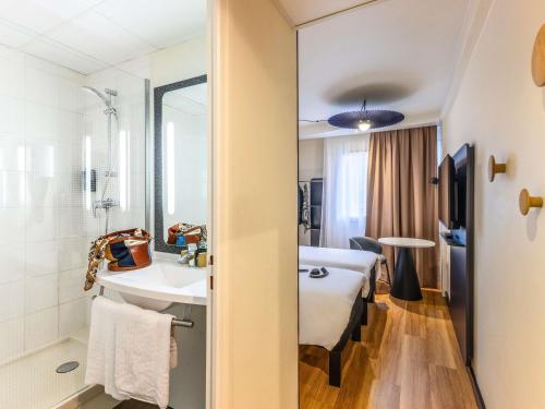 a hotel room with a bed and a bathroom at ibis Dunkerque in Dunkerque
