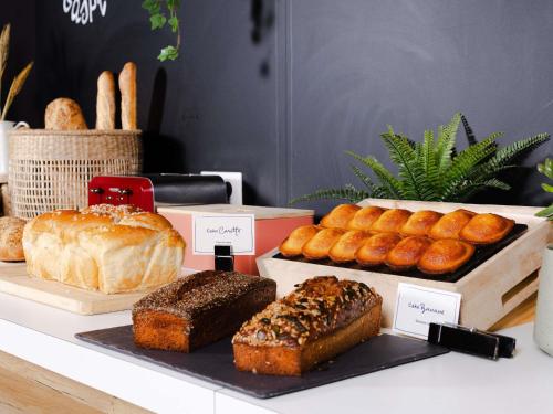 a table with different types of bread and pastries at ibis Valenciennes in Valenciennes
