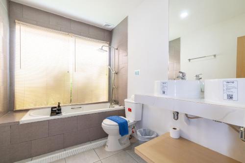 a bathroom with a toilet and a tub and a sink at Andaman Sea Best Pool Access and Villas in Phuket Town