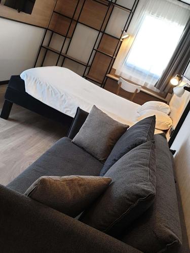a living room with a couch and a bed at ibis Ciboure Saint-Jean-de-Luz in Ciboure