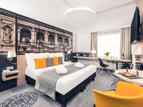a bedroom with a king sized bed and a desk at Mercure Budapest City Center in Budapest