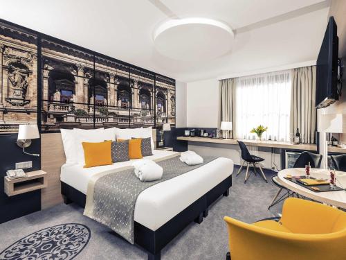a bedroom with a king sized bed and a desk at Mercure Budapest City Center in Budapest