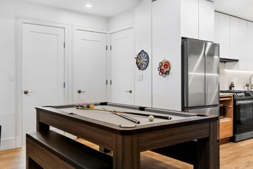 a kitchen with a ping pong table and a refrigerator at Brookline LUX Apt Rooftop GameRoom Subway in Brookline
