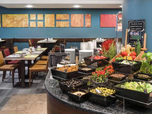 a buffet of food on a counter in a restaurant at Mercure Budapest City Center in Budapest