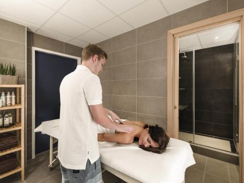 a man is giving a woman a bath on a bed at Mercure Budapest City Center in Budapest