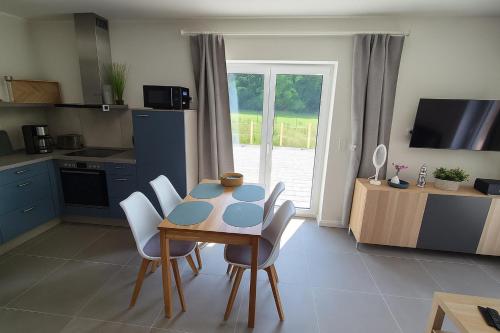 Una cocina con mesa y sillas y una cocina con ventana. en Fiete, en Westhof