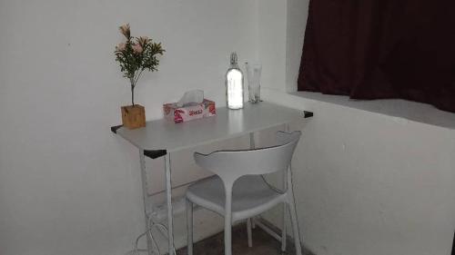 a small white table with a chair and a candle at Hotel Lang Hoose in George Town