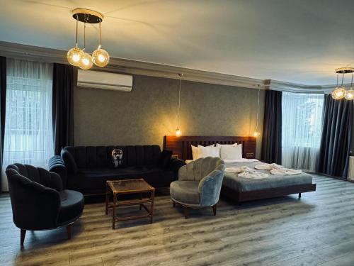 a living room with a bed and a couch and chairs at Treekos Suite Hotel Istanbul Airport in Arnavutköy