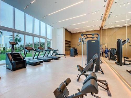 a gym with a row of treadmills and machines at Jumeirah Beach Residences Private Beach & Sea View in Dubai