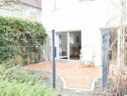 a patio with a fence and a chair at Fördequartier Stadtloft Flensburg in Flensburg