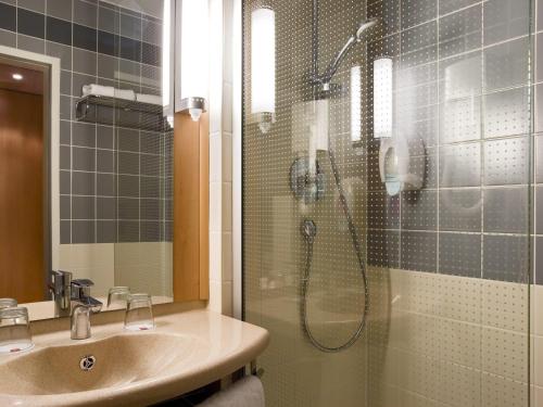 a bathroom with a shower with a sink and a shower at Ibis Budapest Heroes Square in Budapest
