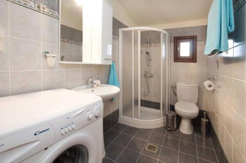 a bathroom with a toilet sink and a washing machine at Endless Blue House in Sami