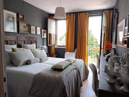 a bedroom with a large bed and a window at Brockwood Manor Tea House - Valdilana in Valle Mosso