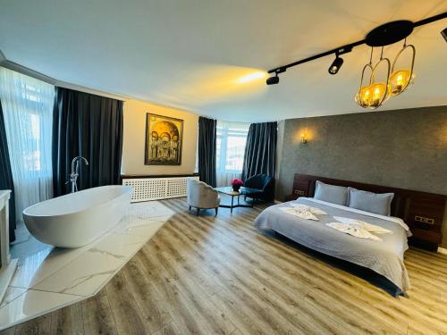 a bedroom with a tub and a bed and a bath room at Treekos Suite Hotel Istanbul Airport in Arnavutköy