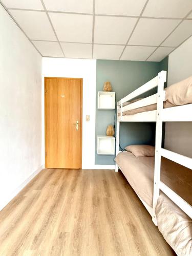 a bedroom with a bunk bed and a wooden floor at Spacious duplex in the center of Bastogne Onikos rooms in Bastogne