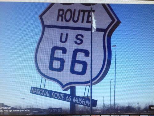 a sign for a route sign on a fence at Sleep Inn & Suites Elk City in Elk City