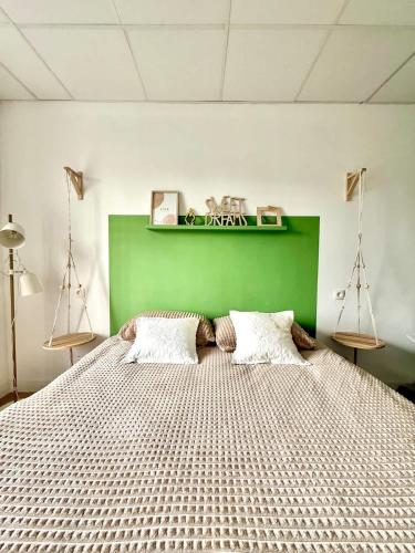 a bedroom with a large bed with a green headboard at Spacious duplex in the center of Bastogne Onikos rooms in Bastogne