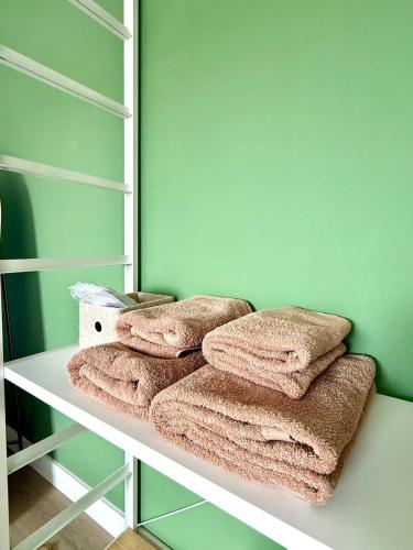 a bunch of towels are sitting on a shelf at Spacious duplex in the center of Bastogne Onikos rooms in Bastogne