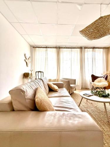 a living room with a large bed and a couch at Spacious duplex in the center of Bastogne Onikos rooms in Bastogne