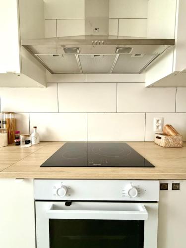 a kitchen with white cabinets and a stove top oven at Spacious duplex in the center of Bastogne Onikos rooms in Bastogne