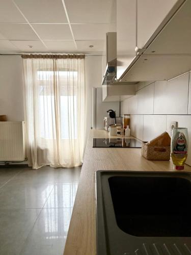 a kitchen with a counter top and a window at Spacious duplex in the center of Bastogne Onikos rooms in Bastogne