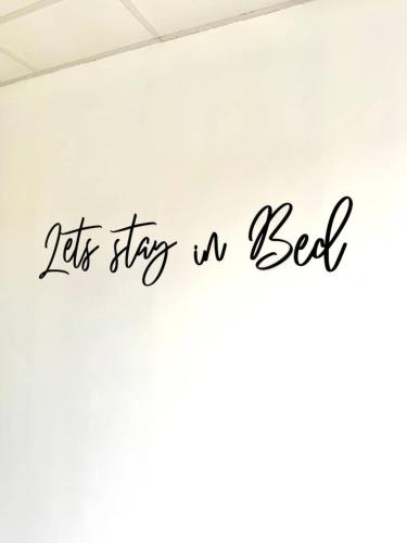 a sign that says lets stays a bed on a wall at Spacious duplex in the center of Bastogne Onikos rooms in Bastogne