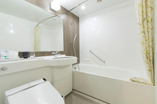 a bathroom with a toilet and a sink and a tub at Mars Garden Hotel Hakata in Fukuoka