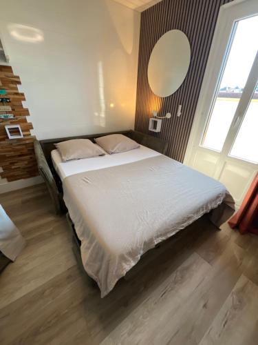 a bedroom with a bed with white sheets and a window at Studio 138 in Annecy