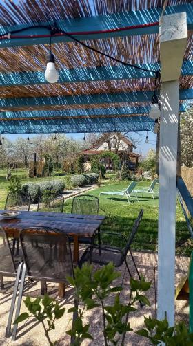 a picnic table and chairs under a blue roof at Holiday Home Paunovaca in Erdut