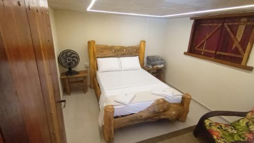Un dormitorio con una cama de madera en una habitación. en Sítio Ouverney, en Nova Friburgo