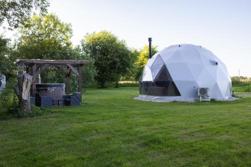 a tent in a field with a gazebo at Žvaigždžių slėnis - Kupolai in Sližiai