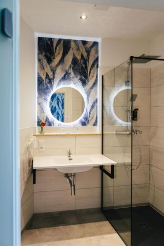 a bathroom with a sink and a shower at Hotel Rabenstein in Raben Steinfeld
